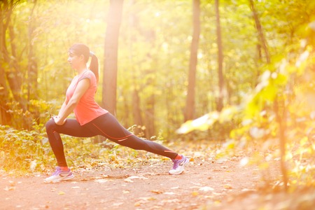 Beautiful young woman practicing or exercising, doing sports in park