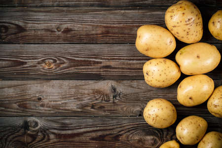 Bunch of potatoes on wooden background close up, space for textの写真素材