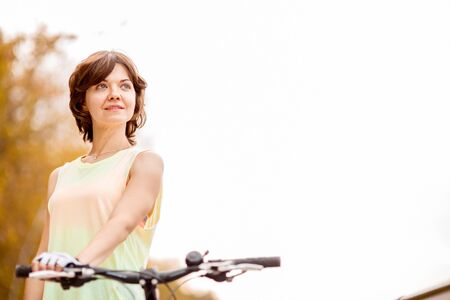 young woman riding bicycle in park, active peopleの写真素材