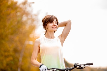 portrait of beautiful young woman with her bike outdoor