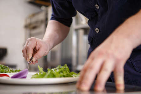 Close up chef preparing food in kitchenの写真素材