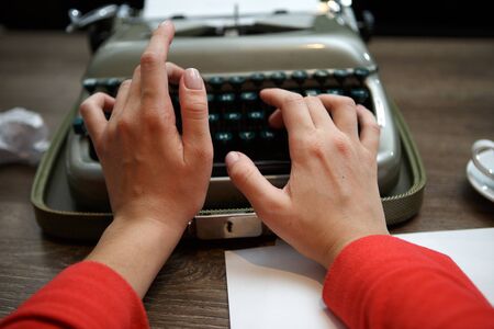closeup of woman typing on old typewriter at tableの写真素材