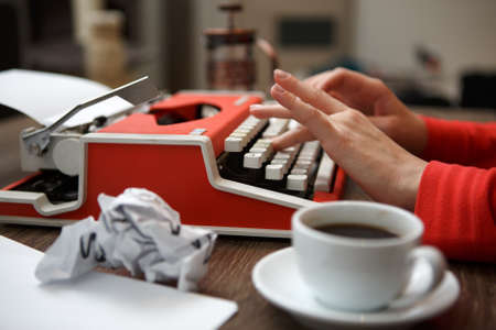 Side view of red typewriter, cup of coffe, crumpled paperの写真素材
