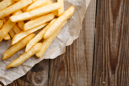 Fresh french fries on wooden table background
