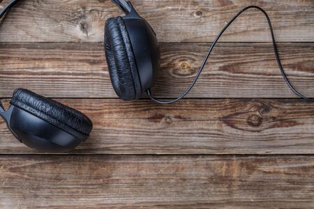 Headphones over wooden table. Top view. Empty space for text, logo, etc.の写真素材