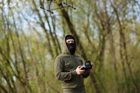 Man in mask operating a drone with remote control. Crime conceptの写真素材
