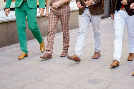 Group of stylish men walking down the street, portrait without facesの写真素材