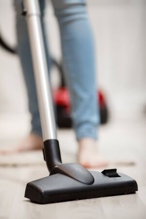 Closeup of head of modern vacuum cleaner. Woman vacuuming in the house conceptの写真素材