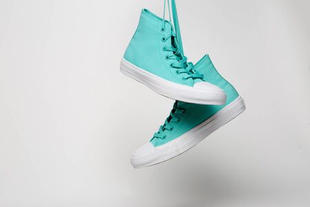 Blue Sport shoes hanging on laces on white backgroundの写真素材