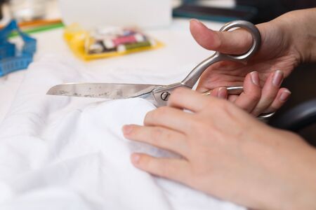 Seamstress cuts cloth pair scissors