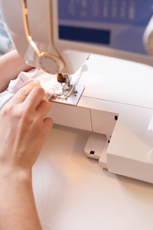 Woman sewing white cloth close-up