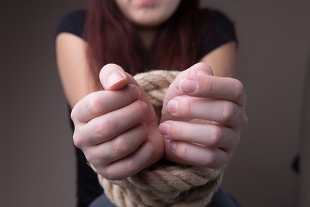 Girl victim with tied handsの写真素材