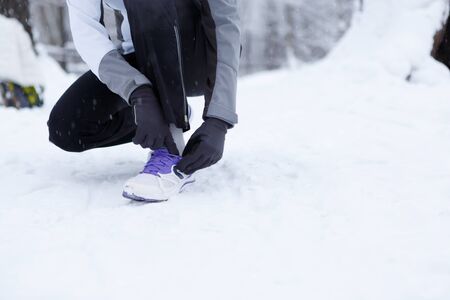 Girl corrects shoes in winter