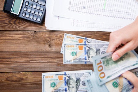 Hands hold and counting us dollar banknotesの写真素材