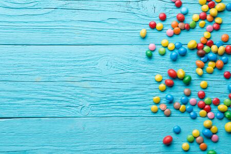 Multicolored candy on wooden table