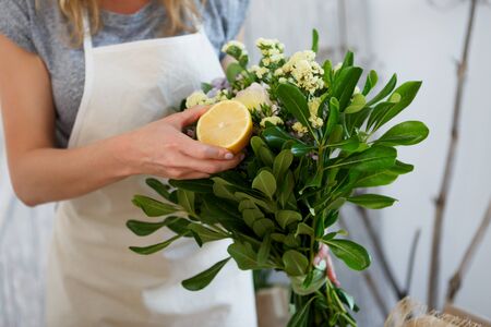 Woman composes bouquet with lemonの写真素材