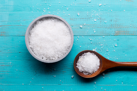 sea salt in bowl and in spoon on wooden backgroundの写真素材