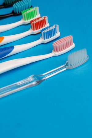 Photo of multi-colored toothbrushes on empty blue background, place for textの写真素材