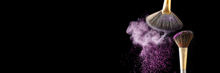 Thick professional brush and loose powder particles scattered aroundの写真素材