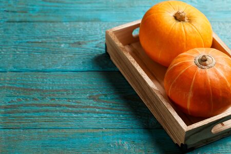 Two pumpkins in wooden box