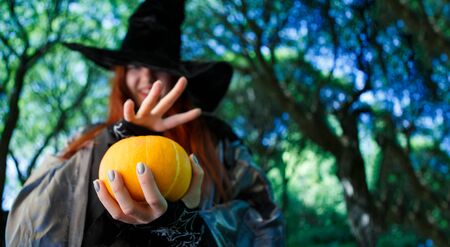 Photo of witch with pumpkin reading spells