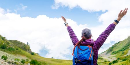 Photo from back of woman against background of hills