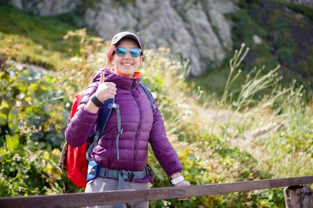 Female tourist in sunglasses against of picturesque mountainsの写真素材