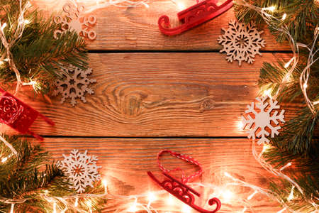 Picture on top of wooden surface with burning garland, branches of spruce, Christmas toys,の写真素材