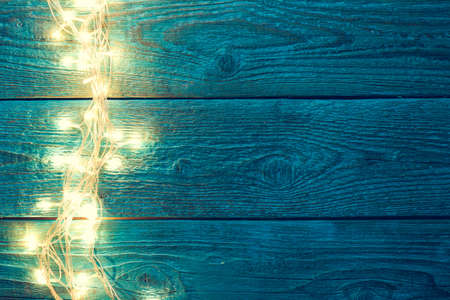 Picture of blue wooden table with burning garland on sideの写真素材