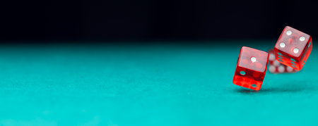 Photo of two dice falling on green tableの写真素材