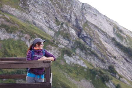 Image of girl in cap standing on bridgeの写真素材