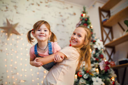 Photo of two sisters in background of New Years decorationsの写真素材