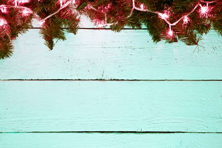 Christmas holiday wooden background with fir tree and golden garの写真素材