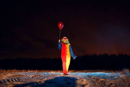 Clown with colorful balloons at nightの写真素材