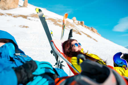 Image of athletes in armchair, skis, sticks in snowy resortの写真素材