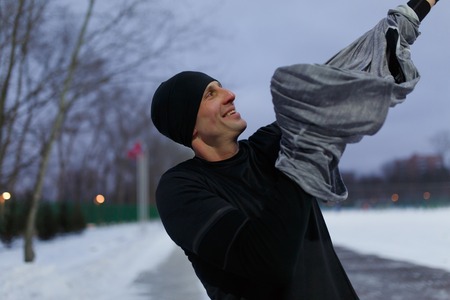 Image of man dressing sweater at stadium on winterの写真素材