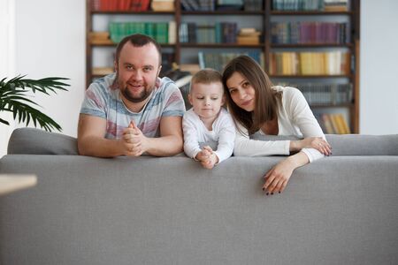 Image of happy woman and man with boys on gray sofaの写真素材