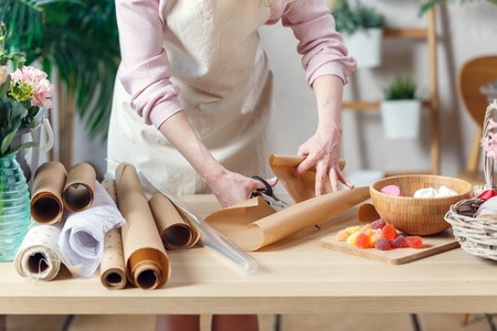 Florist girl cuts wrapping paperの写真素材