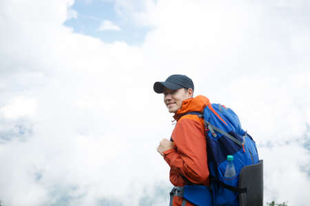 Photo of smiling man from back with backpackの写真素材
