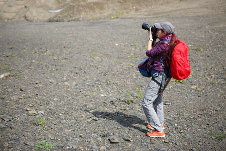Photo of woman with backpack and camera on hill
