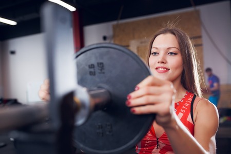 Picture of smiling sportswoman in sports clothes with barbellの写真素材