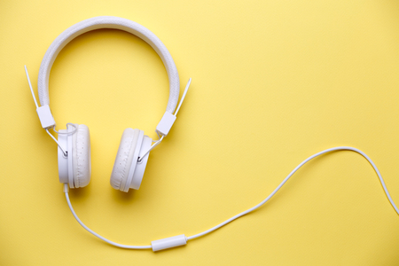 Photo of white headphones for music on yellow backgroundの写真素材