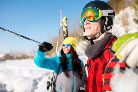 Photo of sports man and woman pointing forward walking on snow hillの写真素材