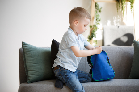Photo of boy with backpack near sofaの写真素材