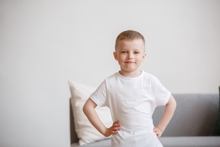 Image of boy in white T-shirt on background of sofaの写真素材