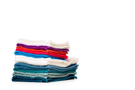 Photo of stacks multi-colored towels on empty white background.の写真素材