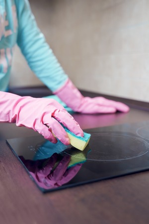Image of female hands in pink rubber gloves washing hobの写真素材