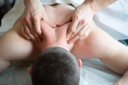 Picture of hands masseur doing massage to young male.の写真素材