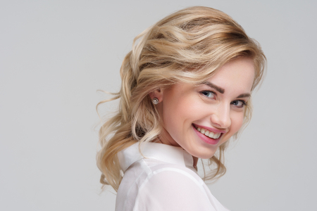 Portrait of curly blonde woman in white shirt.の写真素材