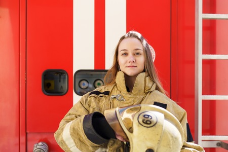 Photo of fire girl standing at fire truckの写真素材